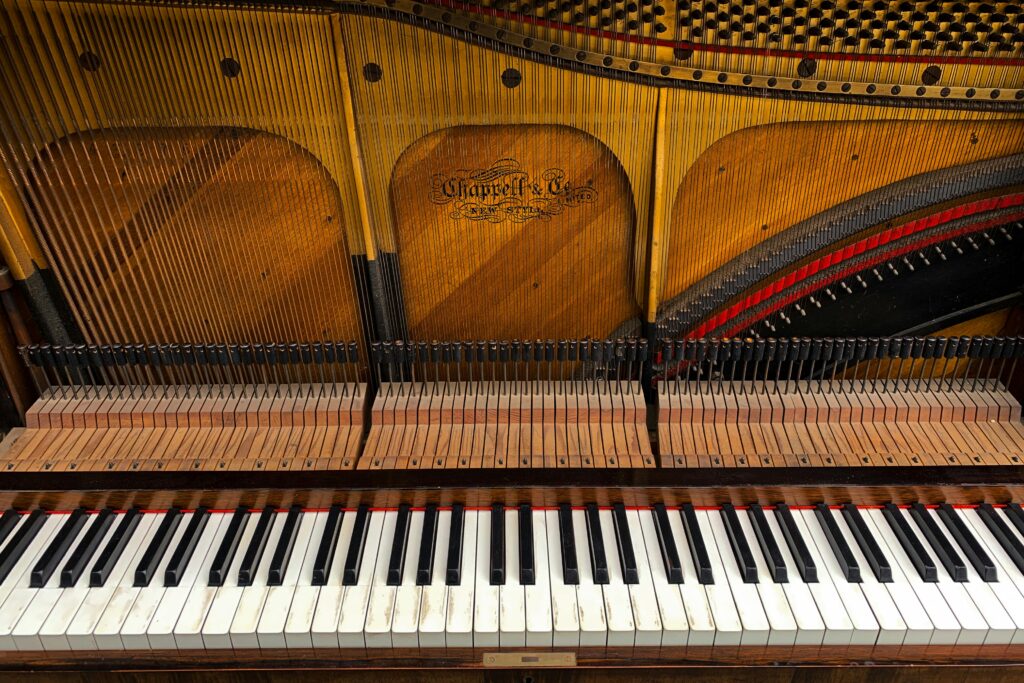 Detailed view of Chappell & Co. grand piano keys and strings inside an acoustic piano.