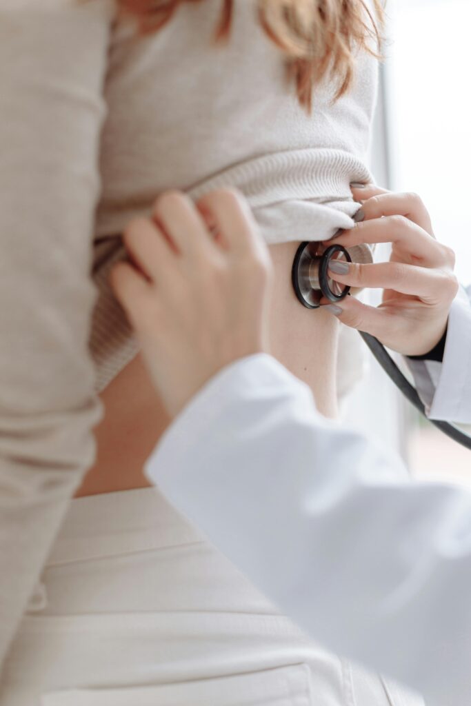 Close-up of doctor using stethoscope on patient's back during medical examination.